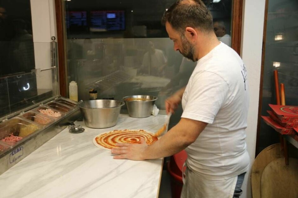 Riad Hanna tillagar en pizza i köket en fredagskväll.
