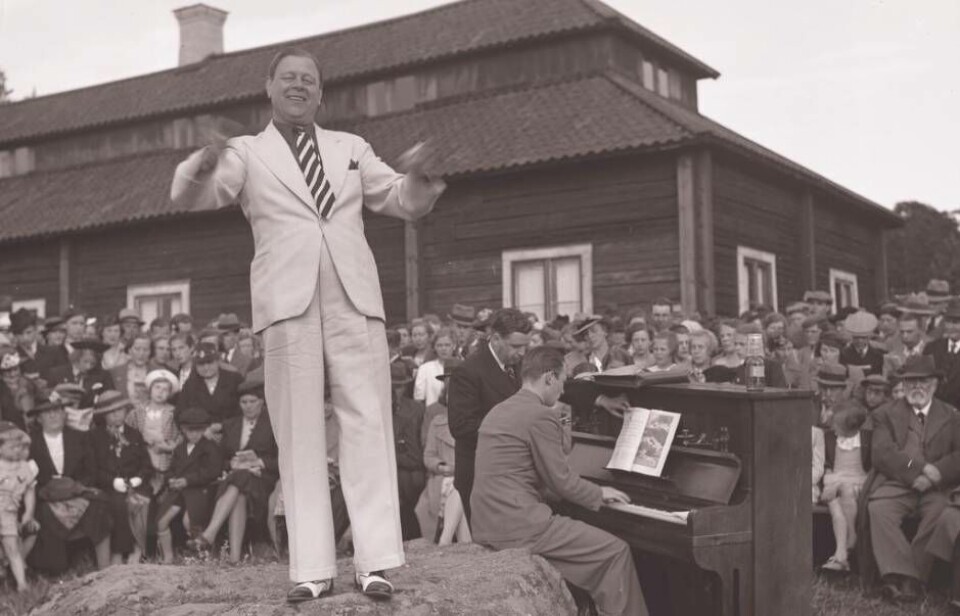 Sven Lilja var med och introducerade allsången i Sverige och ledde Allsång på Skansen under åren 1935-1940. Den vita kostymen var hans signum. Här på 1938 års Sommarfest höll Sven Lilja i allsång även på Vallby. Foto: Arkivet, Västmanlands läns museum