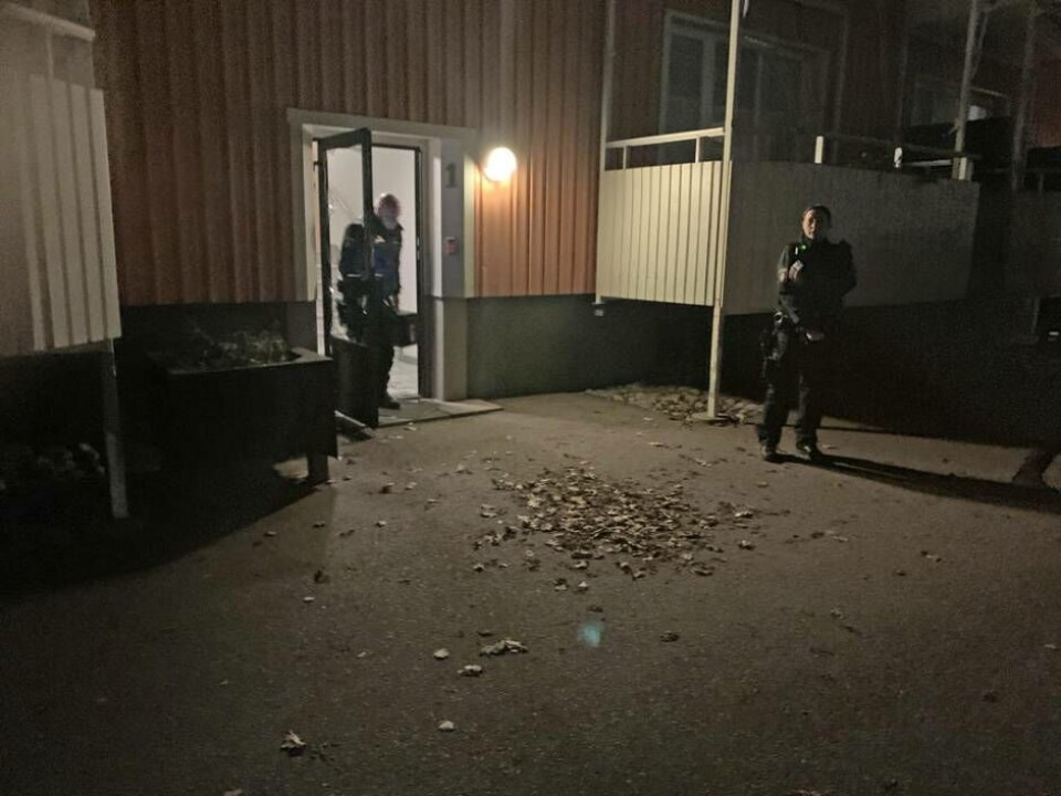 Poliser på plats utanför trappgången till lägenheten där en person uppges ha blivit utsatt för ett våldsbrott.