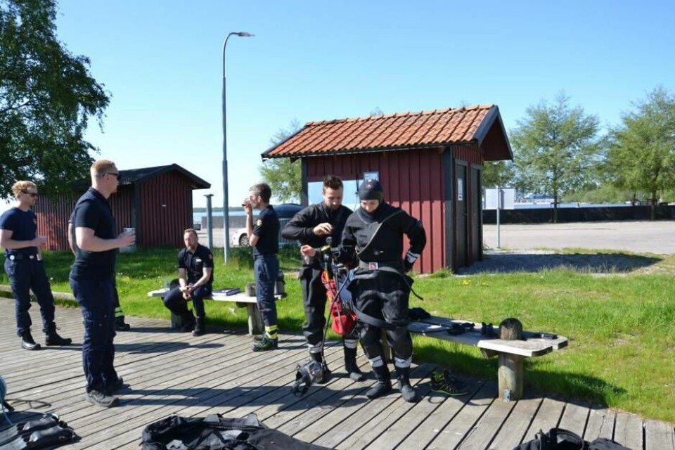 Anton Eriksson hjälper Emma Larsson på med utrustningen inför dykningen i Mälaren. Foto: Helena Andersson