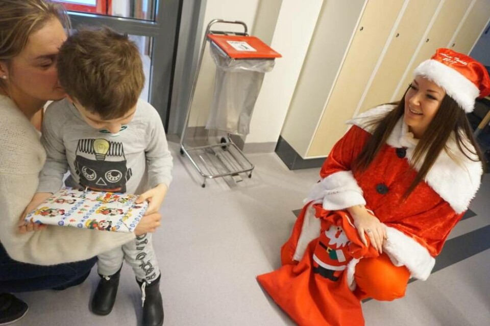 Dino Osmanagic, 3 år, var lite blyg i början, men tog sedan emot sin julklapp av tomte-Olivia med hjälp av sin mamma. Foto: Josefine Wijkström