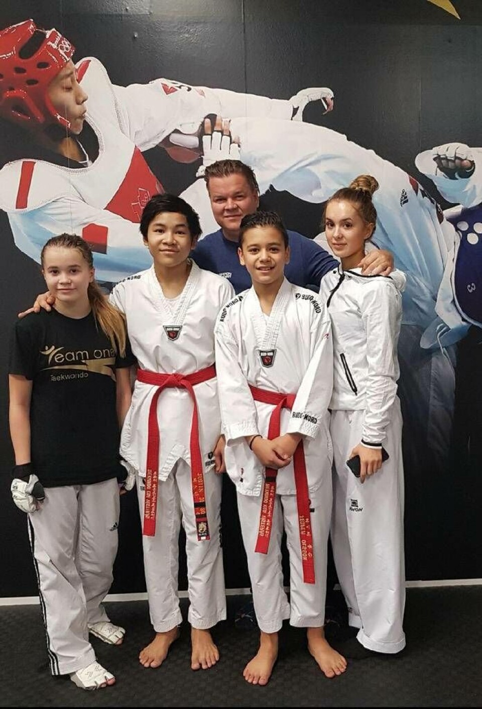Fyra av sex hemmahopp. Team One Taekwondo har totalt sex deltagare med på SM. Här ses från vänster: Nelly Asp, Justin Laloknam, Jesper Laloknam och Hanna Asp. I bakgrunden klubbens huvudinstruktör Jacob Asp. Saknas på bild som SM-deltagare: Isabell Malki och Hamid Afzali. Foto: Team One Taekwondo