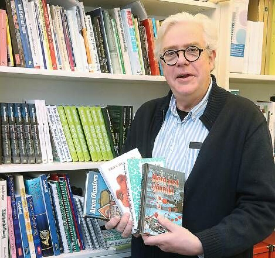 Förläggare Arne Olofsson med några av Aron Olnafors deckare. Foto: Lasse Blom
