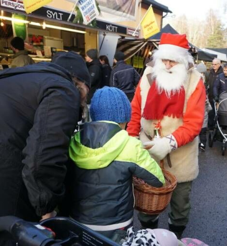 Oskar Isaksson, 7 år, hälsade på tomten och fick lite godis. Mamma Maria, till vänster, berättar att de besöker marknaden för att få lite julstämning