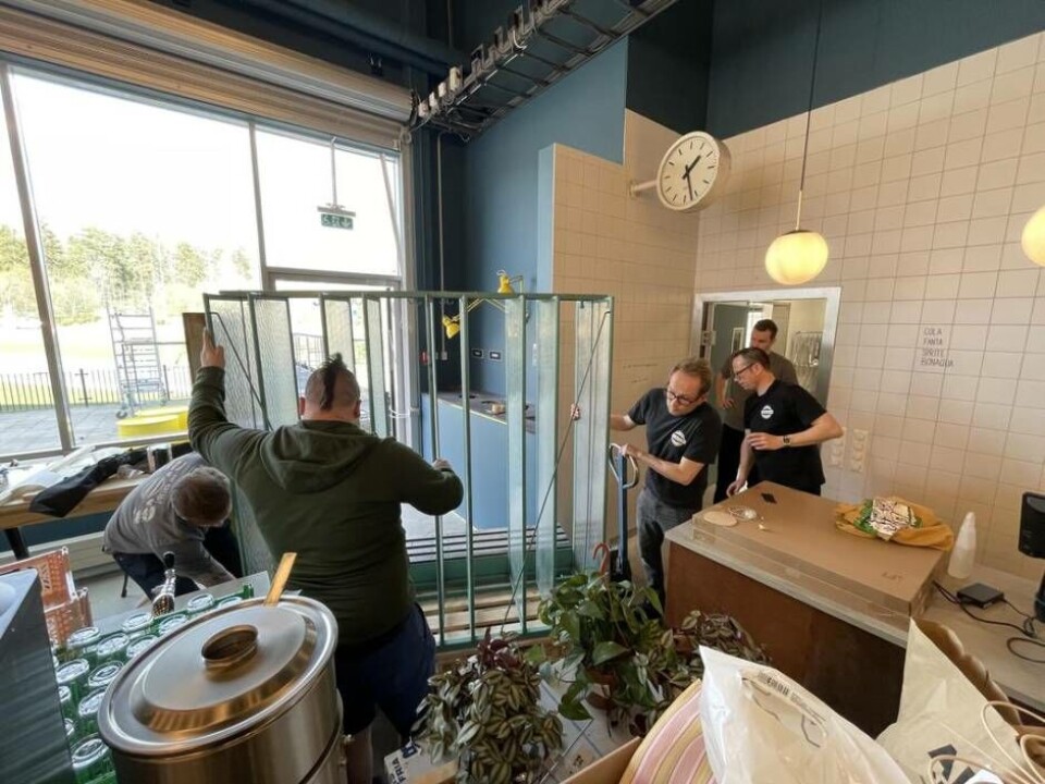 Stora delar av personalstyrkan samarbetar med att få in en stor hylla i köket. Foto: Jonas Edberg