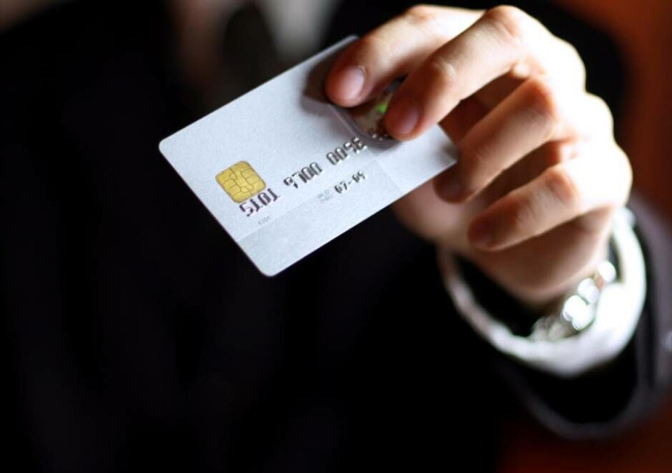 Business man presenting his credit card. Shallow DOF, focus on chip o card. Concept: Shopping and spending.