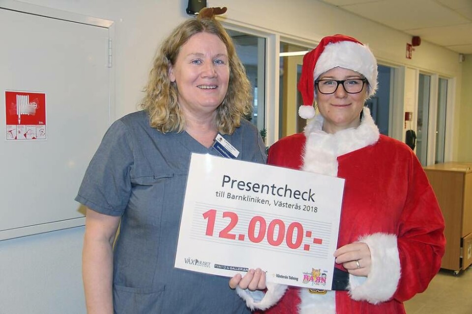 Julgåva. Catrine Nilsson, enhetschef på Barnkliniken tog emot 12 000 kronor av tomten Jonna af Petersens från Västerås Tidning. Foto: Helena Andersson