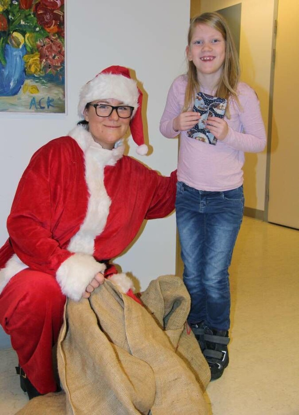 Tomten Jonna af Petersens från Västerås Tidning och en glad Alice Larsson 7 år förstod att tomten hade mycket att göra.– Tomten ska dela ut hundra, tusen, miljoner paket, sa hon. Foto: Helena Andersson