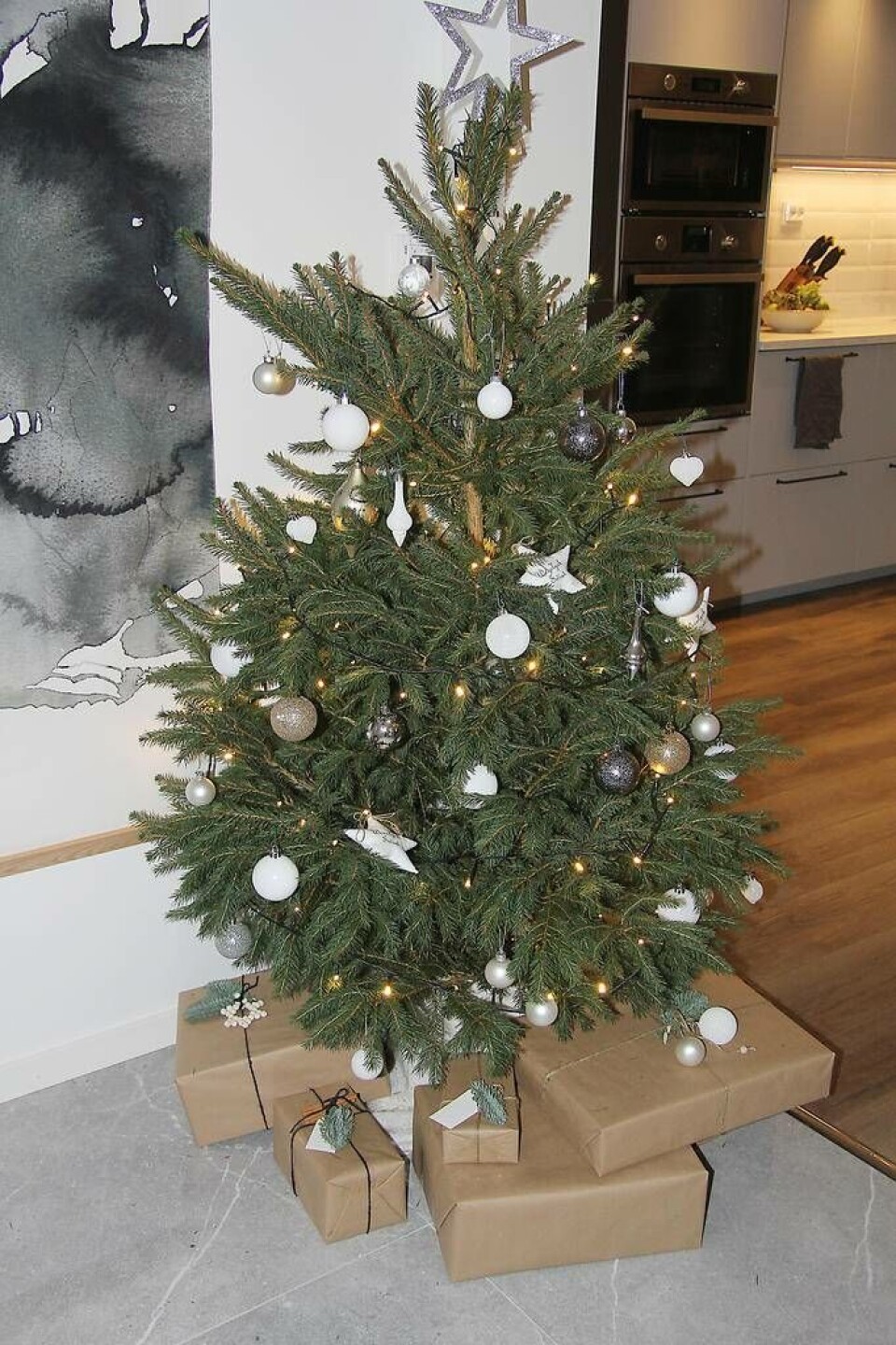 Fin jul. Den stilrena granen i guld, silver och vitt, med paket inslagna i neutralt papper under. Foto: Helena AnderssonI vardagsrummet har Adrianna skapat ett vackert blickfång. Foto: Helena AnderssonDet lyxiga badrummet med dubbla handfat. Foto: Helena Andersson