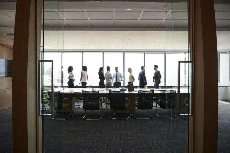 Businesspeople Stand And Chat Before Meeting In Boardroom Foto: Guerilla Productions
