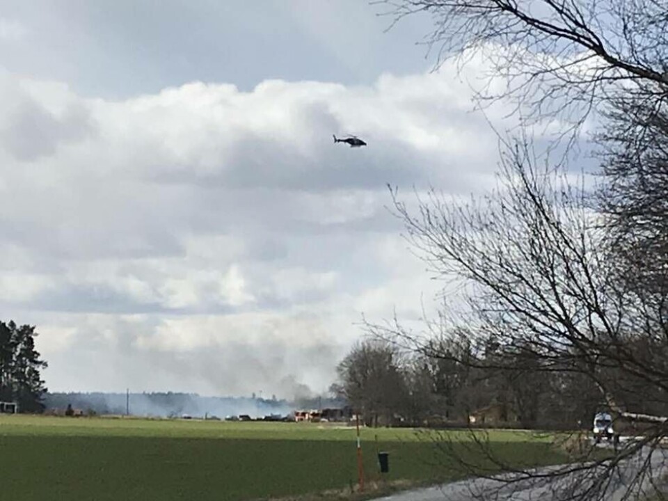 Polisens helikopter jobbar från luften för att undersöka om elden har spridit sig. Foto: Magnus Eriksson