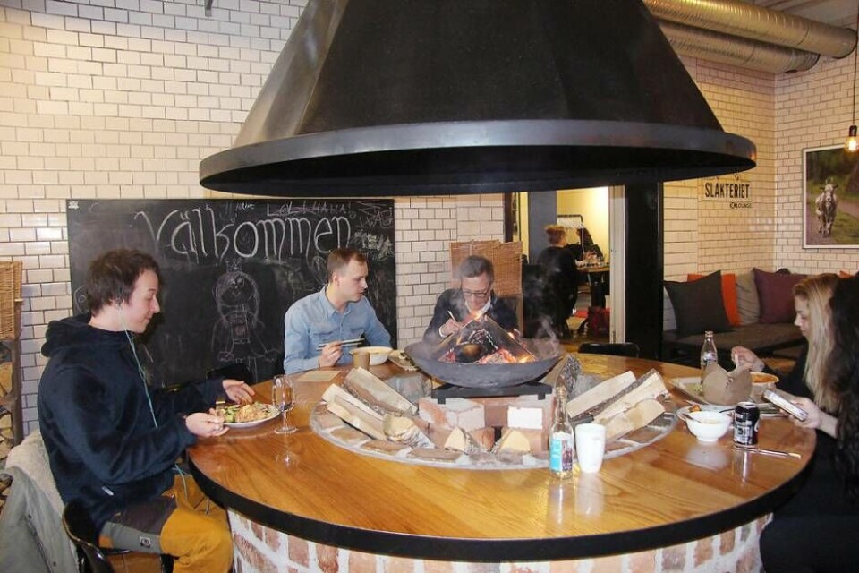 Lunch vid elden. Många bord var fulla under lunchtiden i saluhallen och många ville sitta vid bordet runt elden.