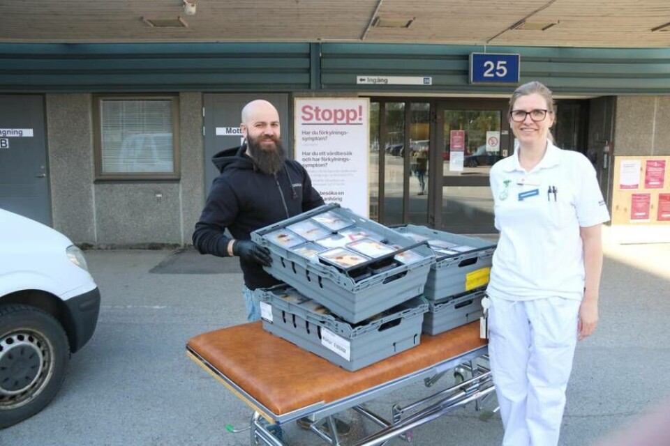 Nabil 'Nabbe' Nader lämnar över 100 matlådor till Elisabet Bogren, enhetssköterska på infektionskliniken. Foto: Helena Andersson