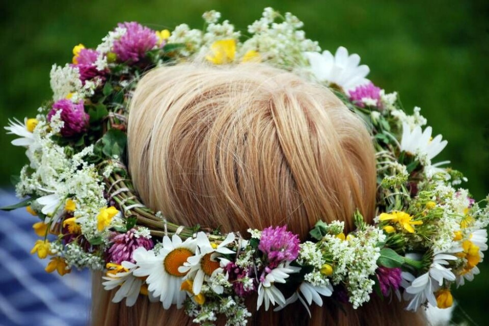 Blommor i håret på midsommarafton. Foto: Mostphotos
