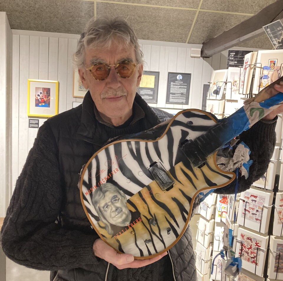 Konstnären och skådespelaren Lasse Åberg med gitarren målad av Jonas Henriksson