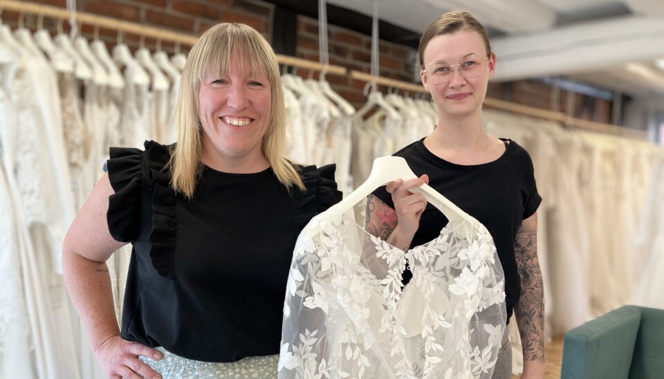 Sara Rousu och Anna Eriksson med en av de vackra bröllopsklänninngarna som finns att köpa på Bröllopsbruket.
