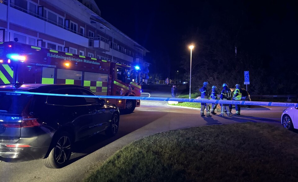 Poliser och brandmän samtalar vid platsen för explosionen.